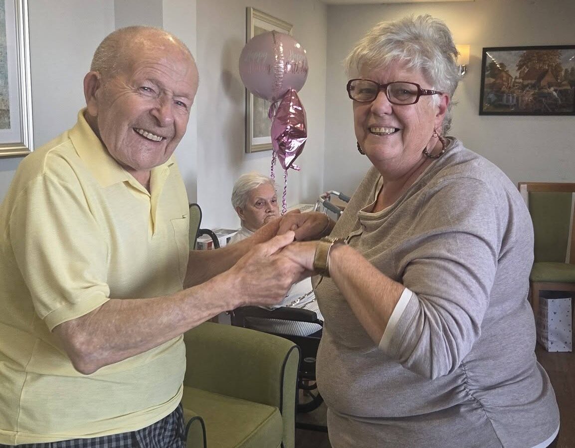 older adults holding hands and smiling